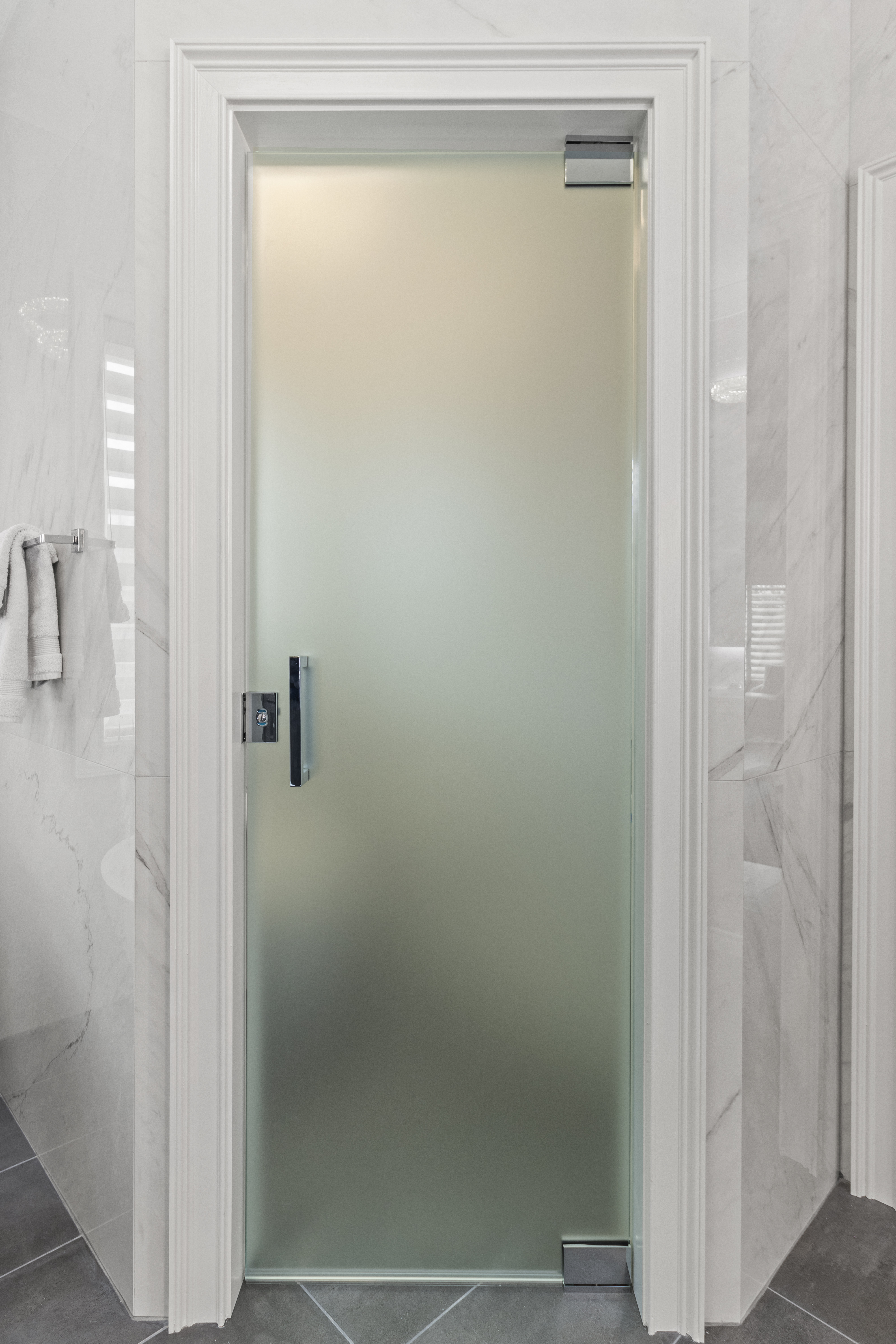 This is a satin/frosted glass toilet partition with a locking mechanism on the door!