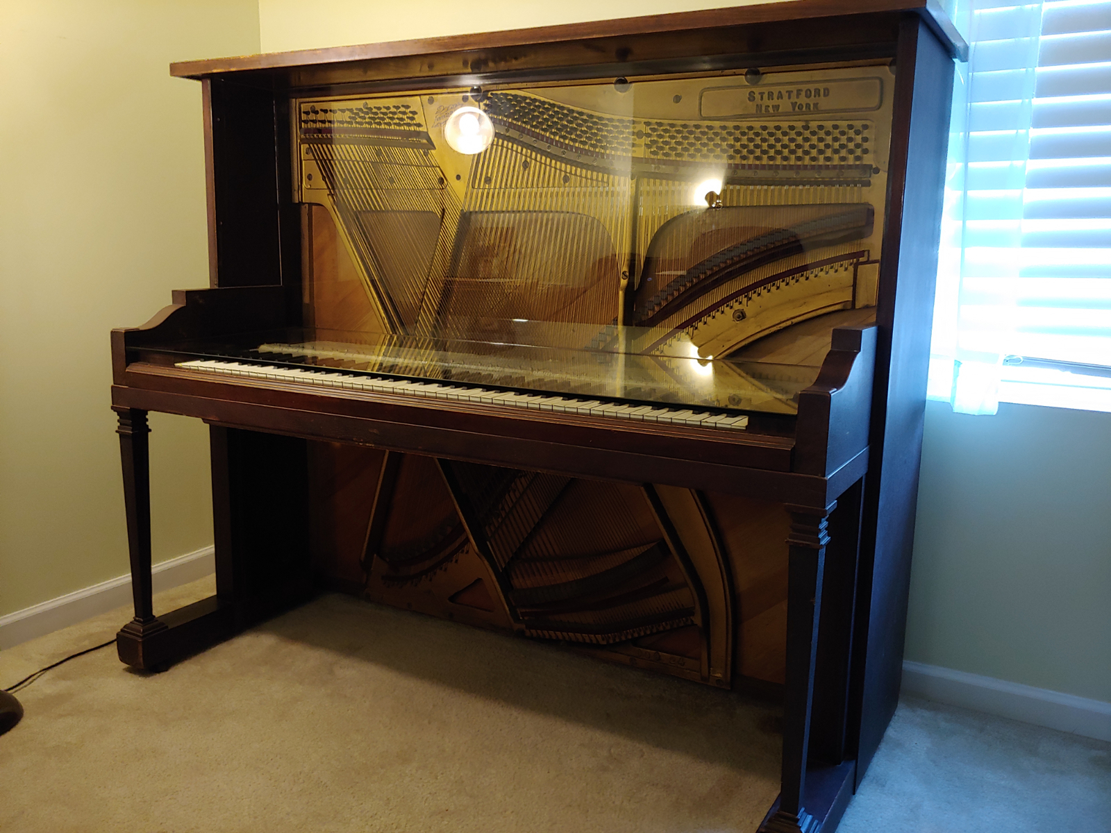 Antique Piano converted to a desk with glass table top and glass backsplash.
